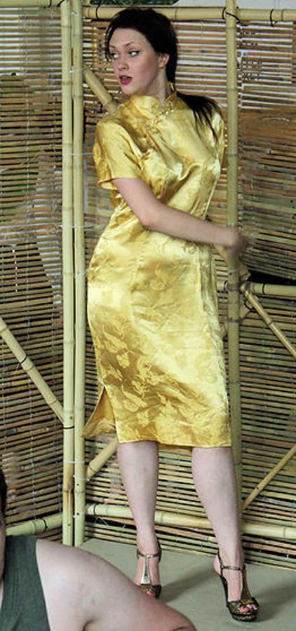 Kim in golden Vietnamese Ao Dai dress in scene from Miss Saigon